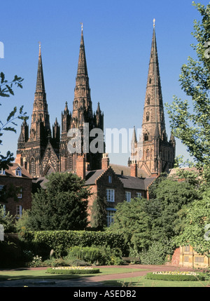 The three spires of medieval English Litcfield Anglican Cathedral building seen from The Remembrance Gardens Staffordshire West Midlands England UK Stock Photo