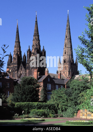 The three spires of medieval English Litcfield Anglican Cathedral building seen from The Remembrance Gardens Staffordshire West Midlands England UK Stock Photo