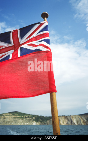 Red Ensign flag flutters in breeze behind boat in Solent English Channel UK Stock Photo