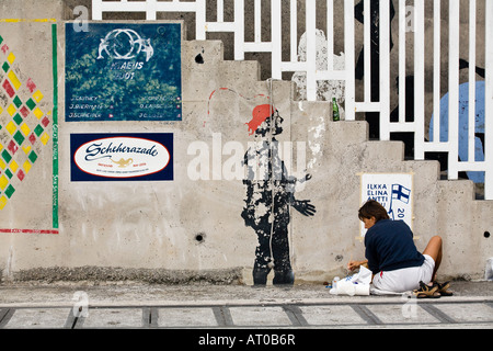 The crew of a yacht paints her name of her boat on the marina wall of Horta. This is along stranding tradition for yachtsman. Stock Photo