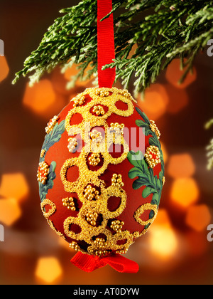 traditional  festive decorated Christmas bauble hanging on a Christmas tree with lights behind Stock Photo