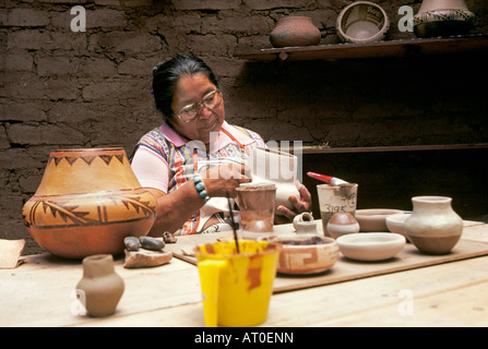 A Jemez Indian woman and Jemez Pueblo in the Jemez Mountains of New Mexico makes traditional native american pottery Stock Photo