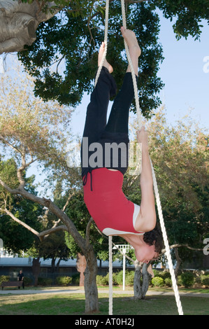 Female acrobat on a trapeze upside down Stock Photo