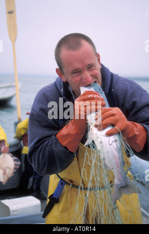 Karl Kircher commercial set net fisherman pretends to take a bite of a Kenai sockeye salmon Oncorhynchus nerka Cook Inlet Alaska Stock Photo