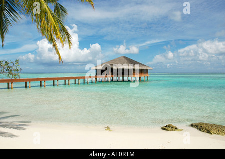 Horizontal wide angle landscape of a mahogany bungalow on stilts in the ocean in the Maldives Stock Photo