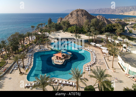 Horizontal aerial wide angle of a hotel swimming pool with a swim up bar surrounded by palm trees on a bright sunny day Stock Photo