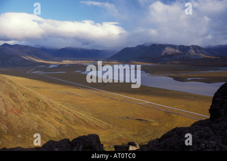 Alaskan pipeline along the Haul road with a pump station in the distance North Slope of the Brooks Range central Arctic Alaska Stock Photo