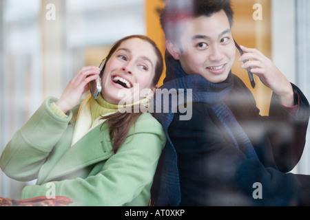 Close-up of a young couple talking on mobile phones Stock Photo