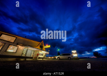 Motel and Restaurant Largo, Quemado, New Mexico at dusk. Open sign; dramatic sky; white Chrysler Town & Country parked in front. Stock Photo