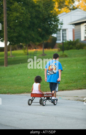 sister pulling brother in wagon Stock Photo - Alamy