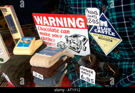 Sign in clothes shop window on high street Hay on Wye Powys Wales UK WARNING CHOCOLATE CAN MAKE YOUR CLOTHES SHRINK Stock Photo