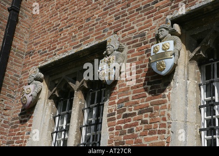 The school in the Oxfordshire village of Ewelme with figures bearing shields on its outside walls founded in 1437 Stock Photo