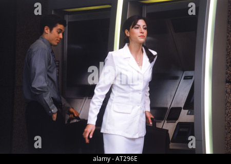 Man looking at attractive woman leaving ATM station Stock Photo