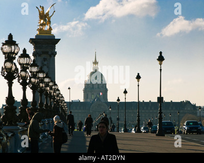 Paris street - People crossing the Pont Alexandre III bridge Paris France Europe looking towards Les Invalides in early morning Stock Photo