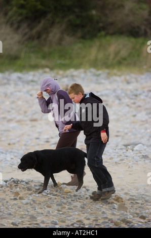 Walking in a strong gale at Horton Beah near Swansea, Wales, UK. Stock Photo