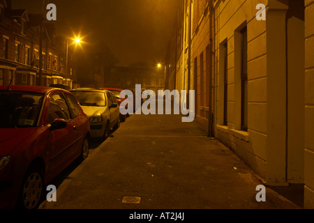 empty deserted footpath on dark nighttime street in Belfast Stock Photo