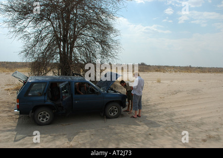 Two Male Tourists with broken down four wheel drive in Kalahari Desert Botswana southern Africa Stock Photo