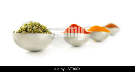 Assorted spices in metal measuring spoons on white background Stock Photo