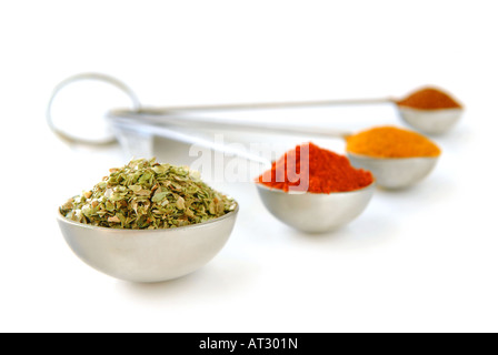 Assorted spices in metal measuring spoons on white background Stock Photo