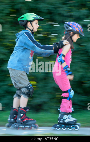 young skater pushing his little sister Stock Photo