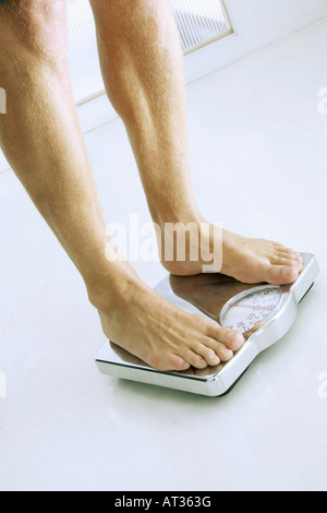 A man standing on bathroom scales - close-up Stock Photo