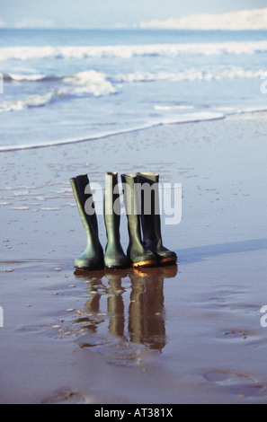 Two pairs of Wellington boots lined up on a beach Stock Photo