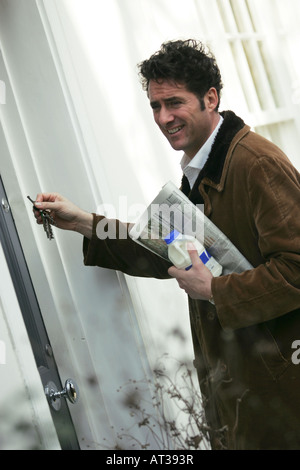 A man unlocking his front door Stock Photo