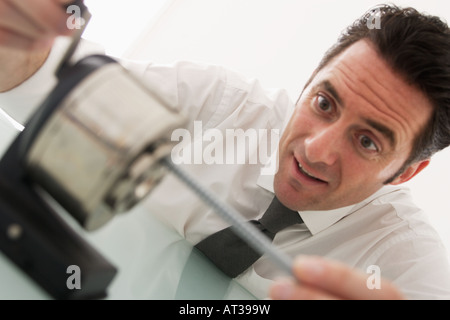 A man sitting at his desk sharpening pencils Stock Photo