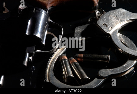 Smith Wesson 38 caliber snub nose revolver with handcuffs and bullets on black reflective background Stock Photo
