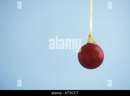 A red bauble hanging on a gold ribbon Stock Photo