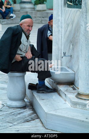 Old man washes his feet at the New Mosque in Istanbul, Turkey Stock Photo