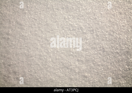 Pure white Unblemished snow in soap flake like crystals with sun shining off the surface. Stock Photo