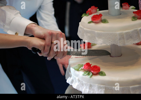 A newly married couple pictured cutting their weding cake Stock Photo