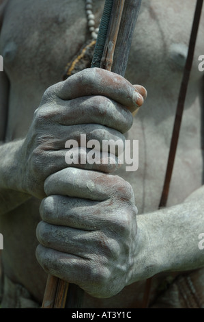 Hands holding bow arrows spears Goroka mudmen show sing sing Stock Photo