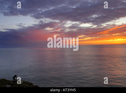 Photographer shooting South Stack lighthouse at sunset Holy Island Anglesey Wales Stock Photo