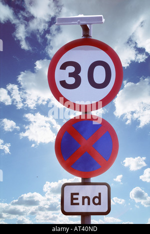 Traffic signs against a cloudy blue sky in the UK Stock Photo