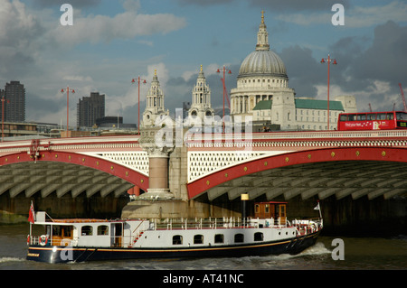 Boat on River Thames passing under Blackfriars Bridge with St Paul's Cathedral in the background Stock Photo