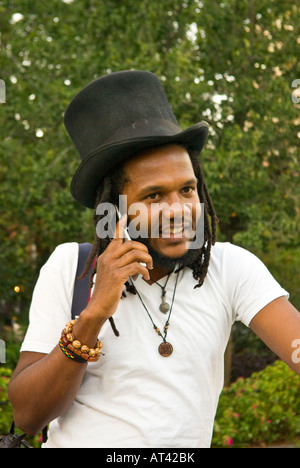 man, afro american, with top hat on mobile phone Stock Photo