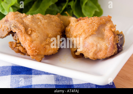 A plate of golden deep fried chicken thighs displayed with a range of packaged dips Stock Photo