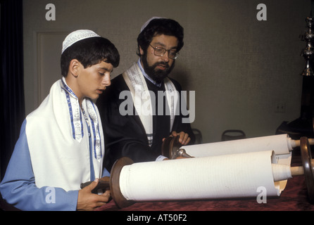 Rabbi and teenager reading from the Torah Stock Photo