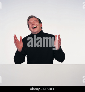 man laughing behind wall Stock Photo