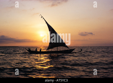 A traditional Luo sailing canoe with Jaluo fishermen on board setting off at dawn to fishing grounds on Lake Victoria Kenya Stock Photo