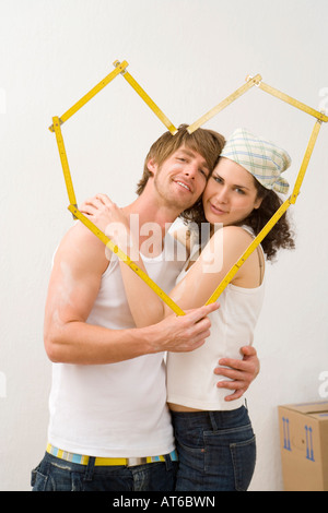 Young couple with folding ruler heart-shaped, close-up