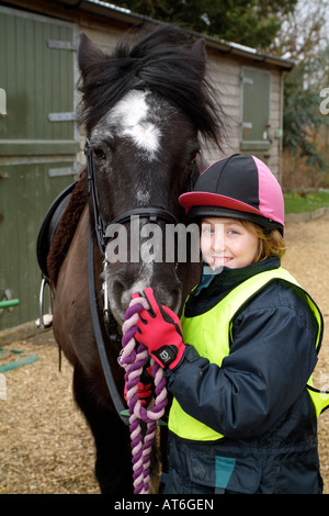 Pony Rider Little Girl holding her pet Cob Pony Stock Photo