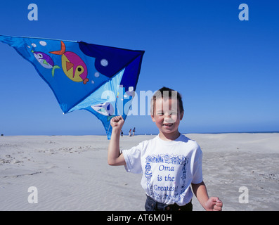 A young boy flies a kite on the beach in Newport Oregon Stock Photo