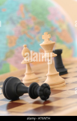 Chess pieces with globe in background Stock Photo