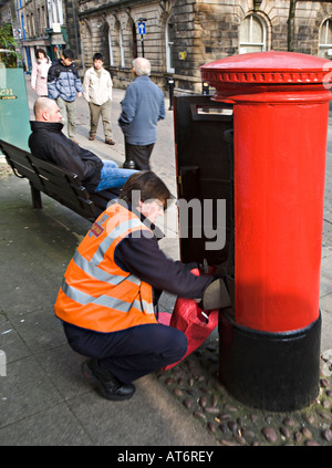 Postman emptying red postbox Lancaster UK Stock Photo