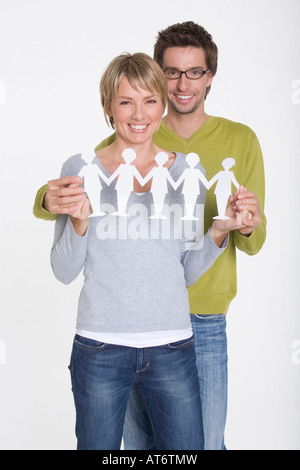 Young couple holding paper cutouts, portrait Stock Photo