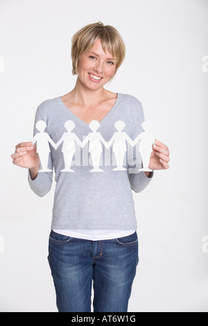 Young woman holding paper cutouts, portrait Stock Photo