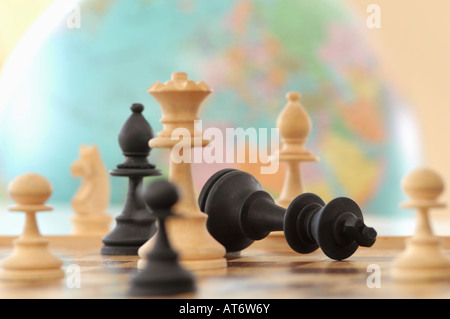 Chess pieces with globe in background Stock Photo